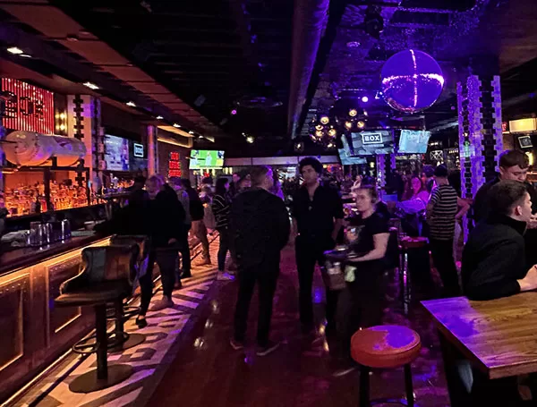 Technician installing LED video wall and speakers in a bar venue